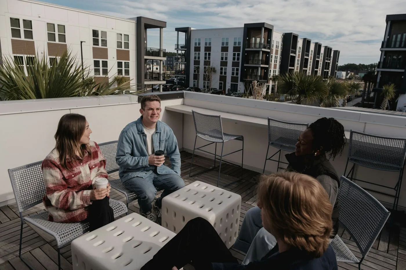 Bewohner im Gespräch auf der Dachterrasse einer modernen Wohnanlage